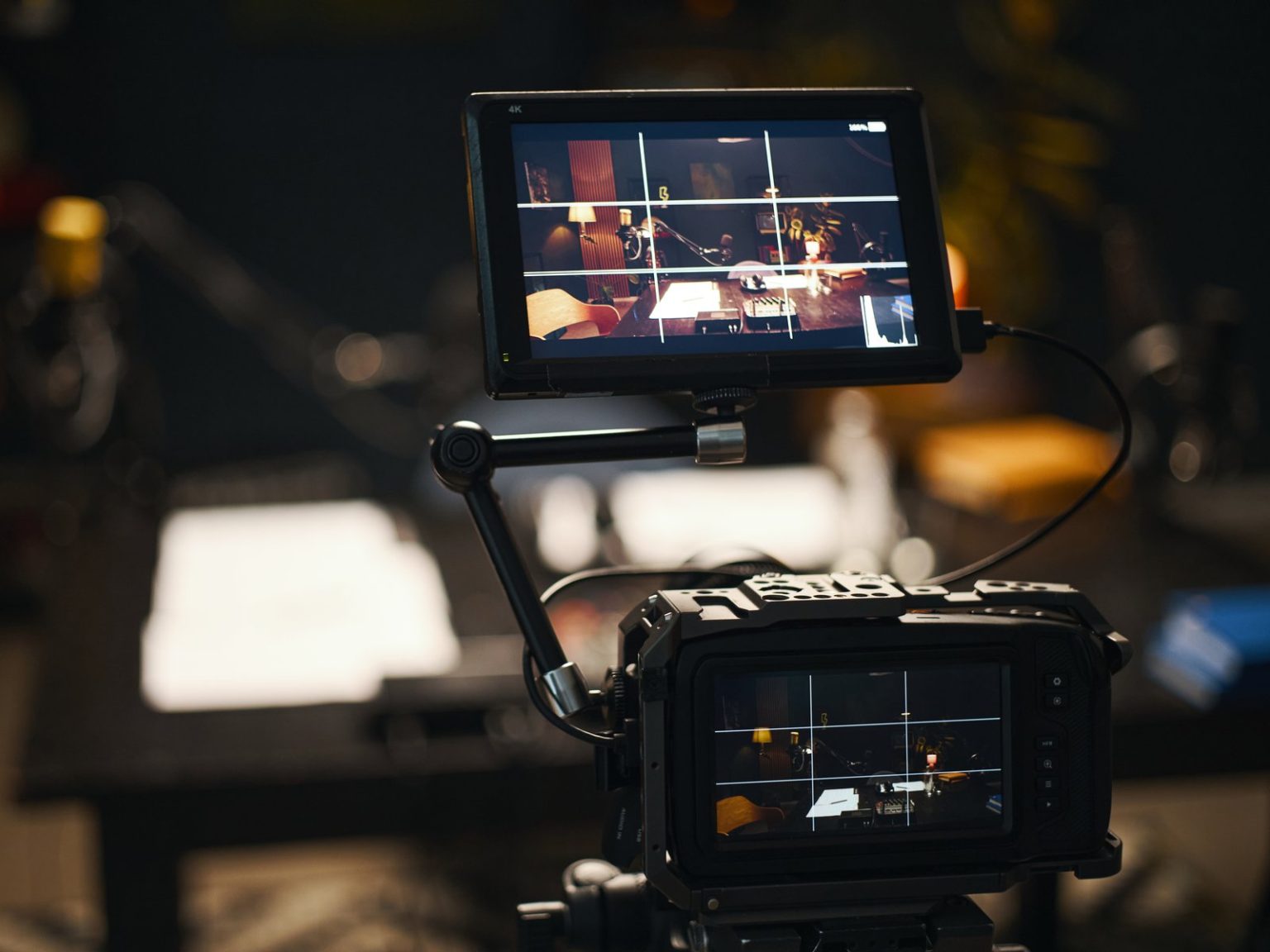 Field monitor on a camera rig showing the framed shot in a dark studio