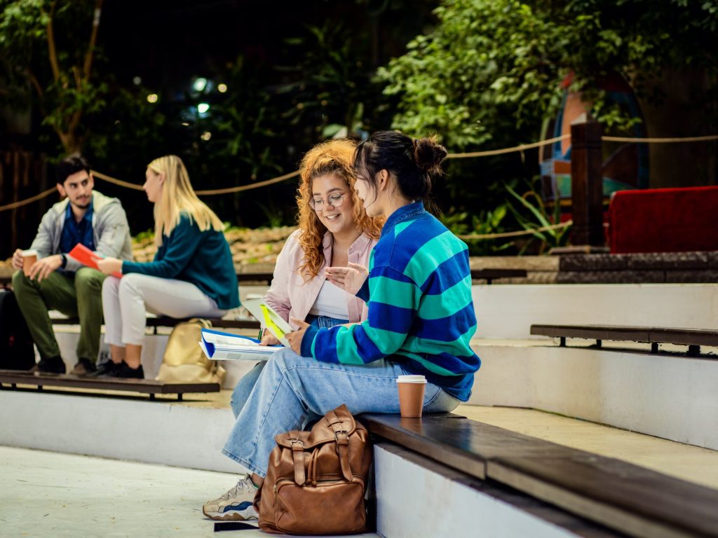 Students studying together outdoors on campus in the evening